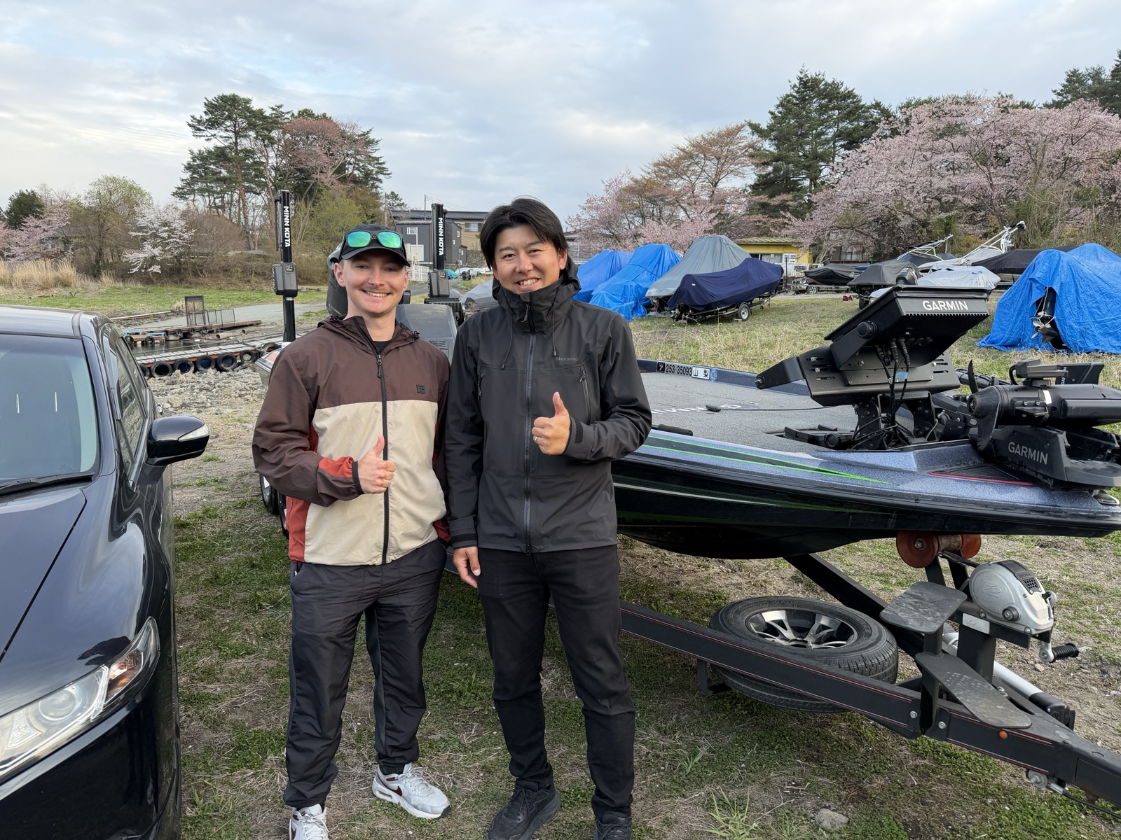 International guest and local fishing guide in front of a bass boat at Lake Kawaguchi