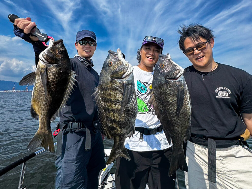 Three anglers holding chinu (black seabream) caught on an Osaka Bay charter